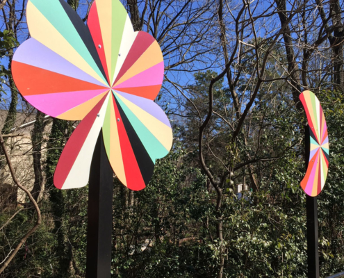 Detail of two of the 4’ x 4’ x 10’ aluminum pinwheels in a kaleidoscope of colors that flank the two lane road of the Plaza Shamrock Neighborhood bridge in Charlotte, NC.